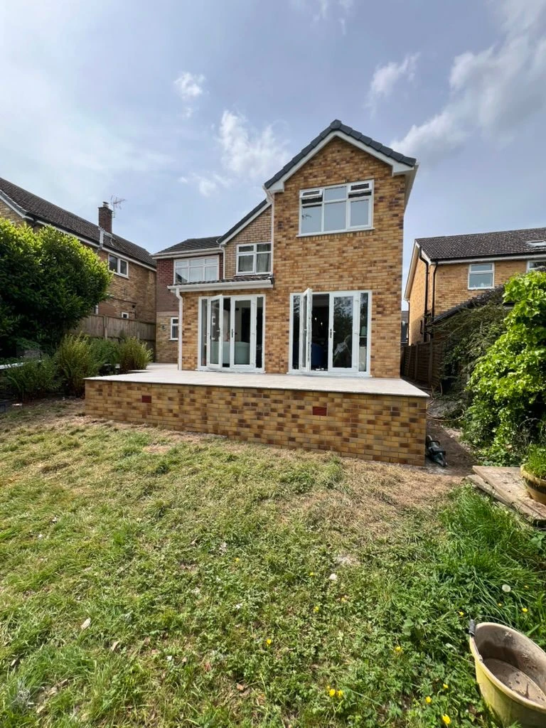 A brick house with a large lawn in front of it.